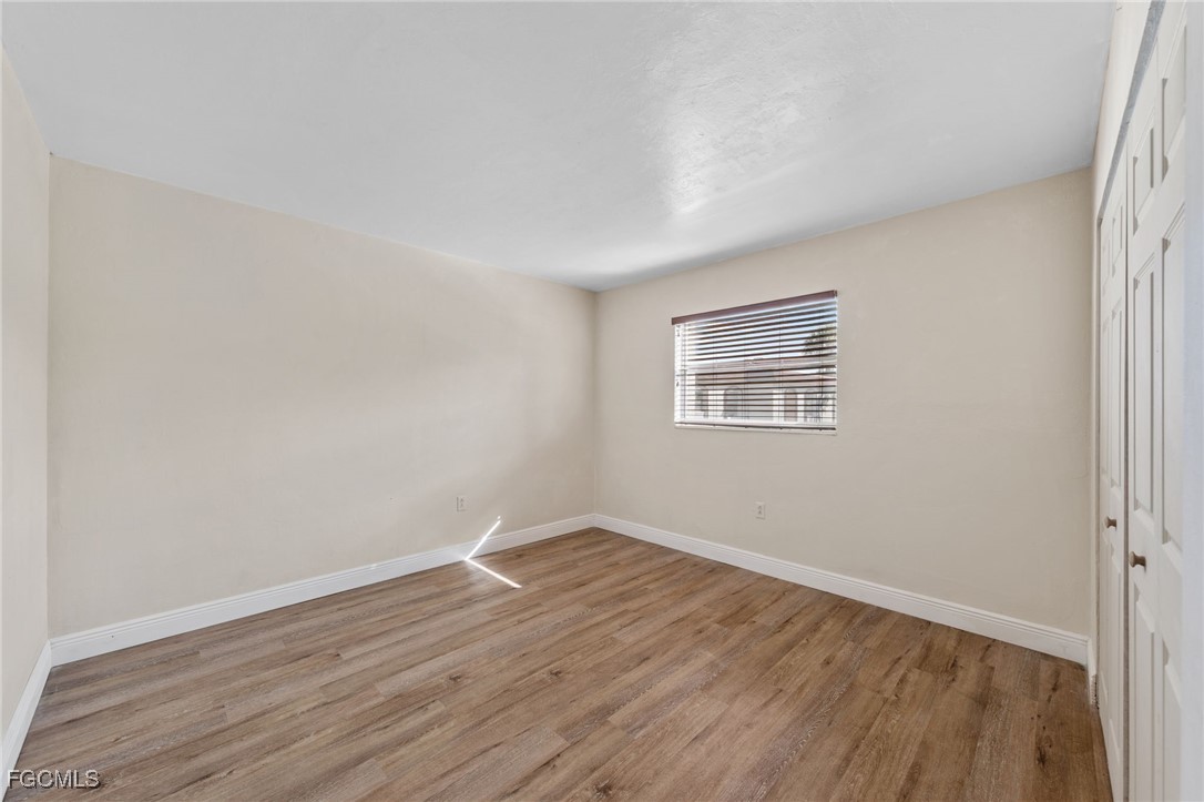 2828 Jackson Street, Unit D8 Fort Myers, FL 33901 - Photo 22 of 37 an empty room with wooden floor and windows
