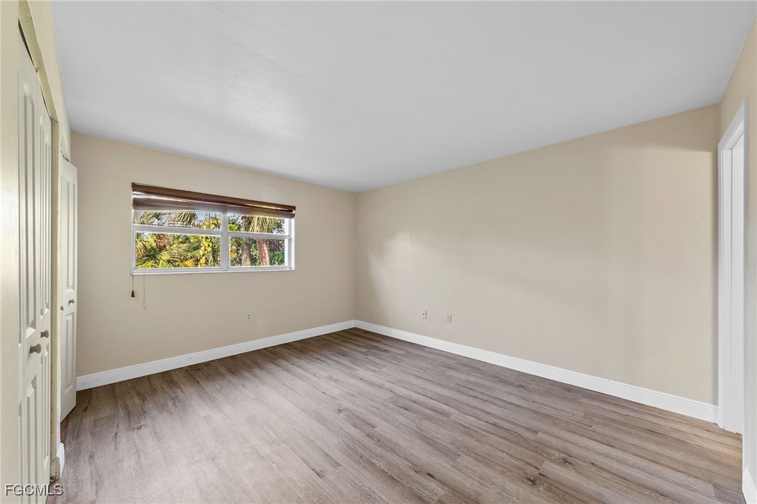 2828 Jackson Street, Unit D8 Fort Myers, FL 33901 - Photo 25 of 37 an empty room with wooden floor and windows