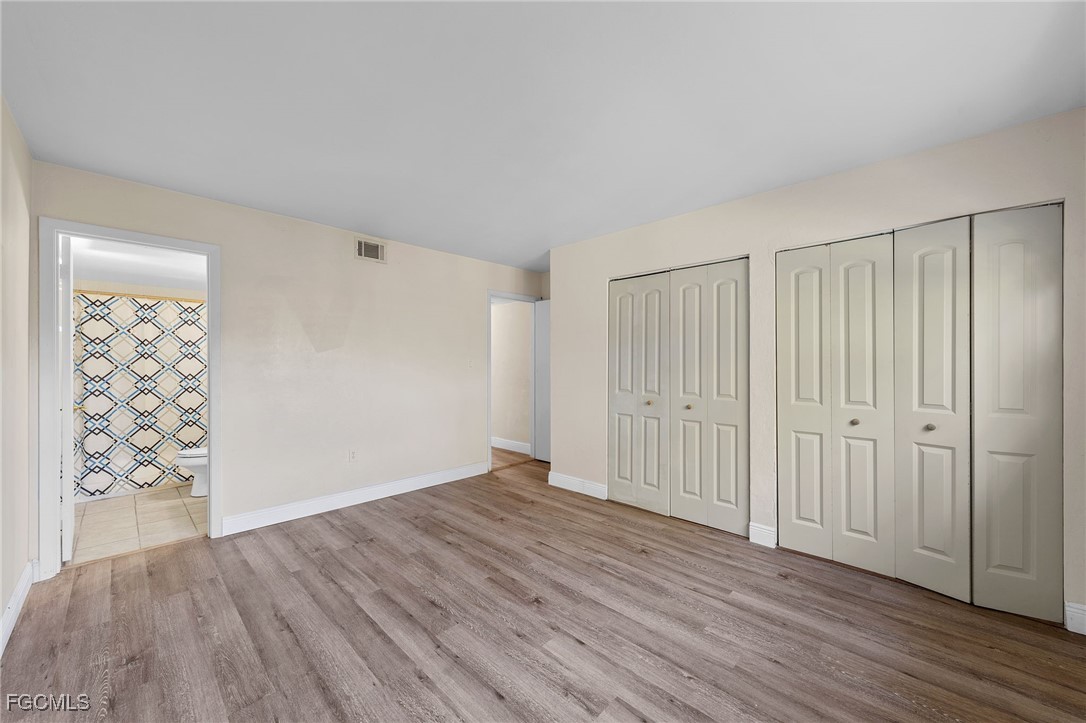 2828 Jackson Street, Unit D8 Fort Myers, FL 33901 - Photo 26 of 37 a view of an empty room with wooden floor and entryway