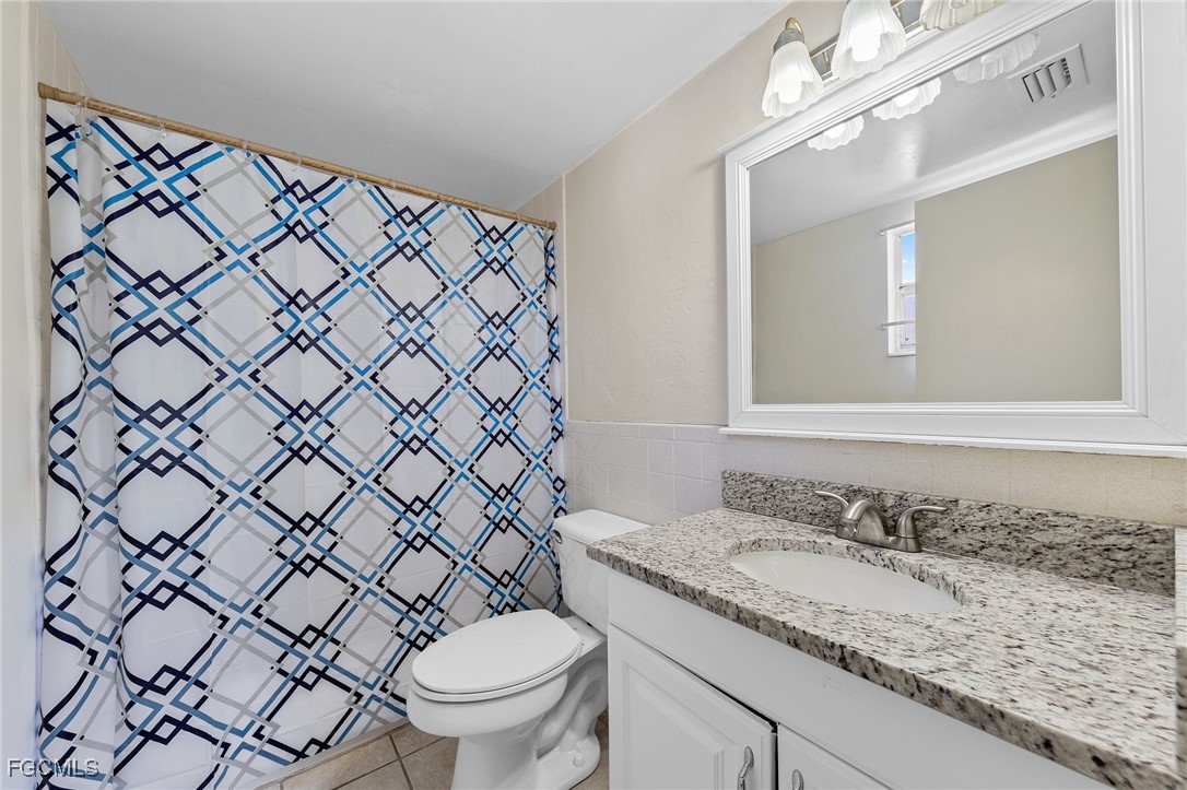 2828 Jackson Street, Unit D8 Fort Myers, FL 33901 - Photo 27 of 37 a bathroom with a granite countertop sink and a mirror