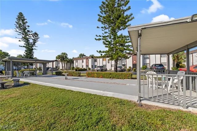 front view of a house with a yard and palm trees
