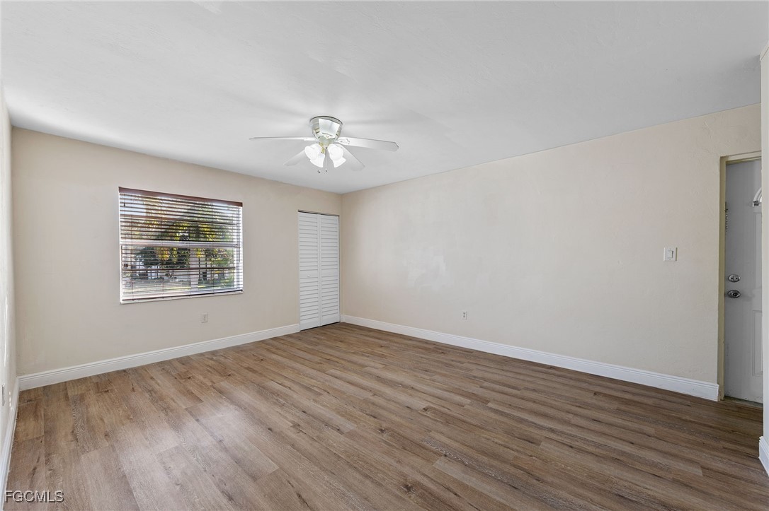 2828 Jackson Street, Unit D8 Fort Myers, FL 33901 - Photo 6 of 37 a view of an empty room with a window and wooden floor