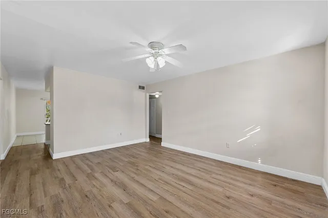 a view of an empty room with wooden floor