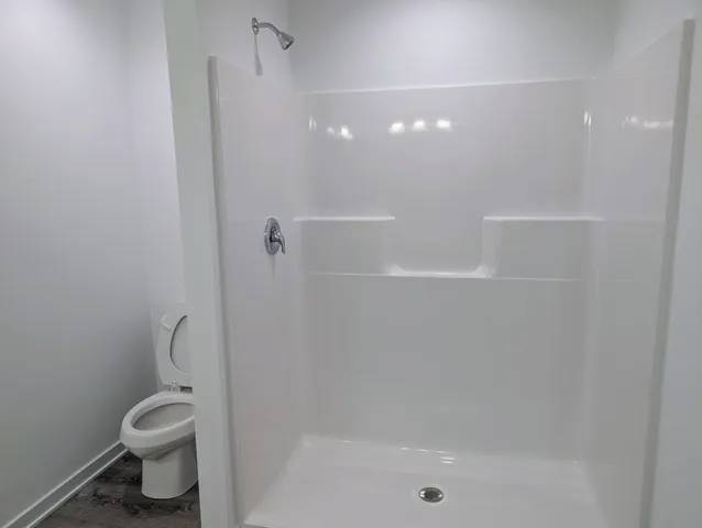 a bathroom with a shower a toilet and a sink