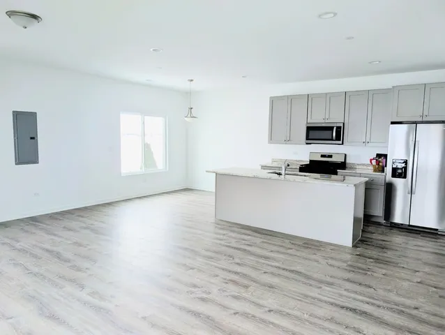 a kitchen with stainless steel appliances a refrigerator sink and white cabinets