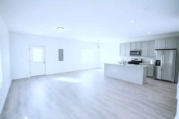 a view of kitchen with granite countertop stainless steel appliances refrigerator sink and cabinets