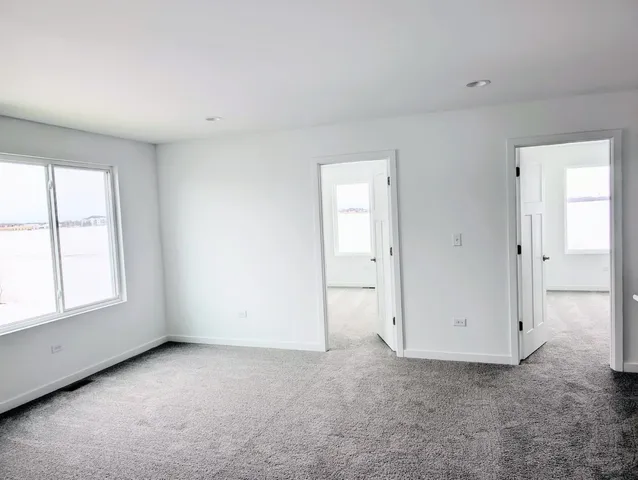 an empty room with windows and closet