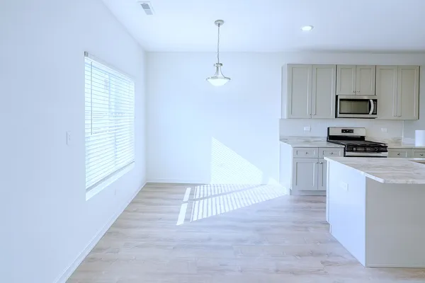 a kitchen with kitchen island white cabinets and black appliances