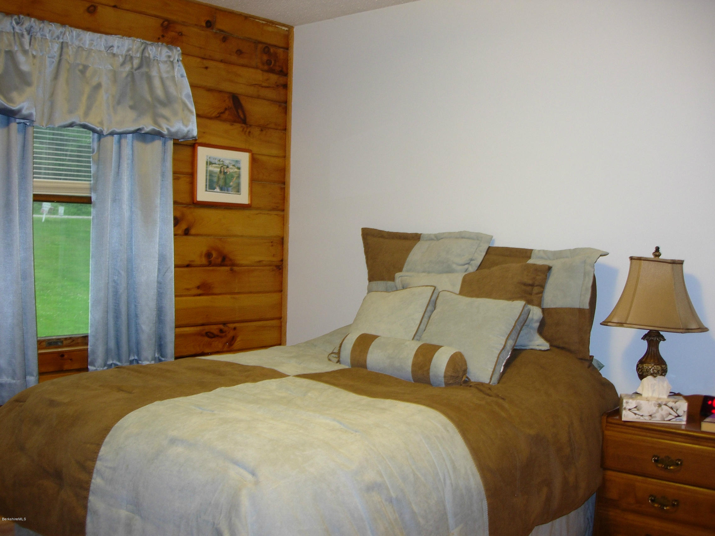 99 Strykers Road Florida, MA 01247 - Photo 15 of 26 a bed sitting in a bedroom next to a window and a wooden floor