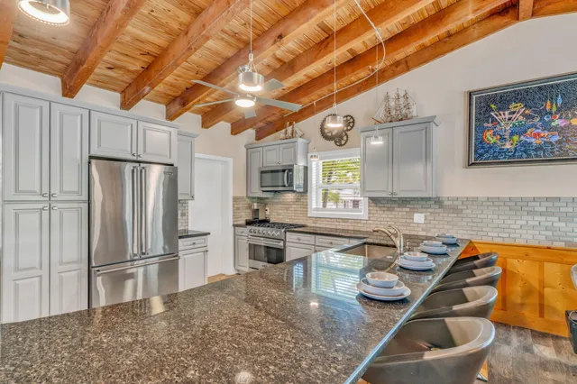 a kitchen with stainless steel appliances granite countertop a sink a stove and a refrigerator