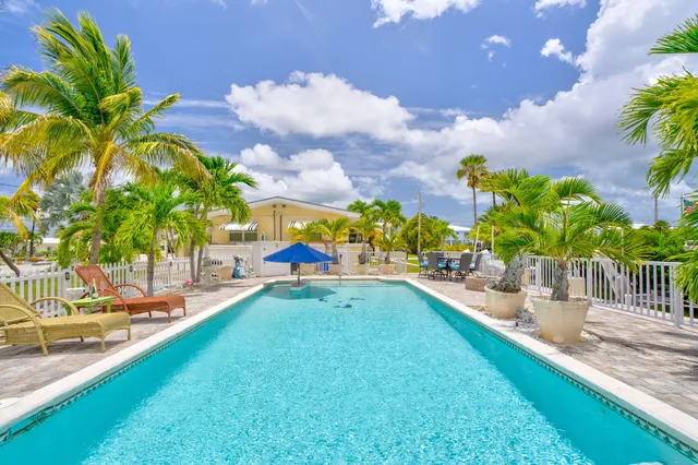 a view of a swimming pool with a lawn chairs and a yard