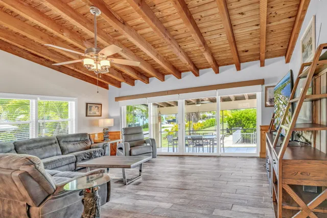a living room with furniture tv and large windows