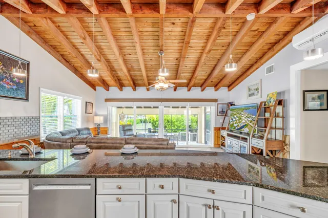 a kitchen with stainless steel appliances granite countertop a sink window and cabinets