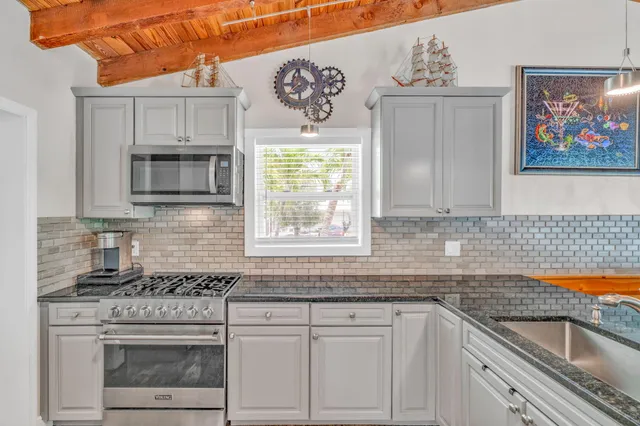 a kitchen with stainless steel appliances granite countertop a stove a microwave and cabinets