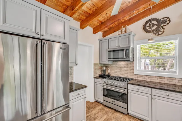 a kitchen with stainless steel appliances granite countertop a refrigerator and a stove top oven