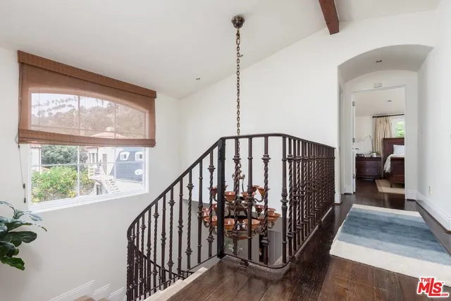 a view of a hallway with wooden floor and stairs