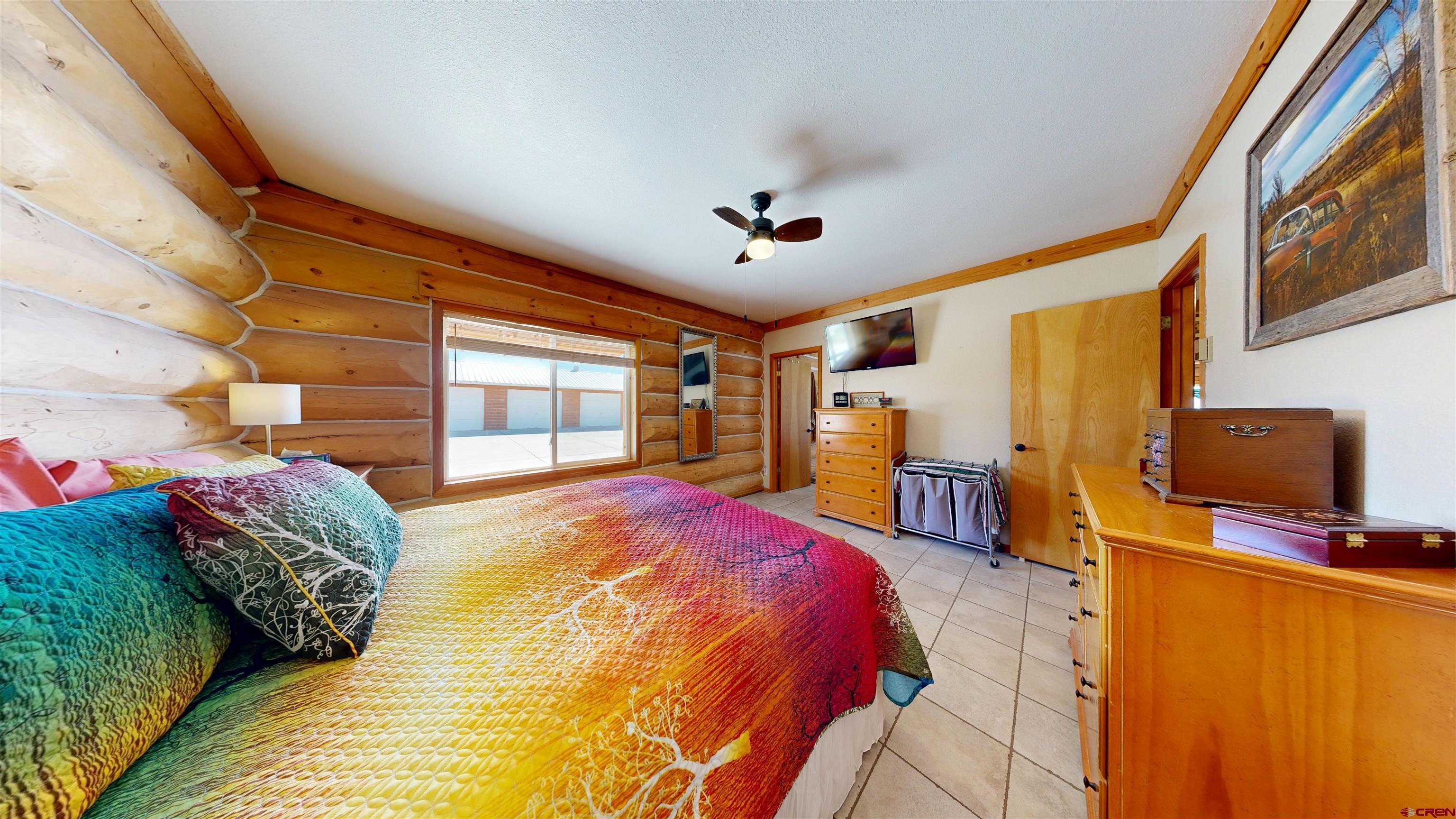 2083 Pioneer Road Delta, CO 81416 - Photo 24 of 45 a spacious bedroom with a bed and a flat tv screen on dresser
