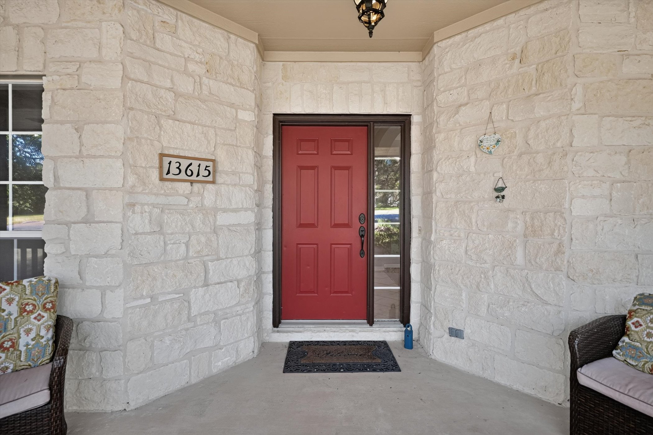 13615 Copperleaf Trail Manchaca, TX 78652 - Photo 10 of 38 A vibrant red entry door welcomes guests to this inviting stone-clad home.