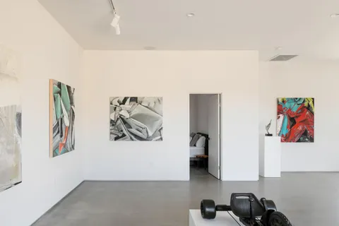 a bedroom with a bed and painting on the wall