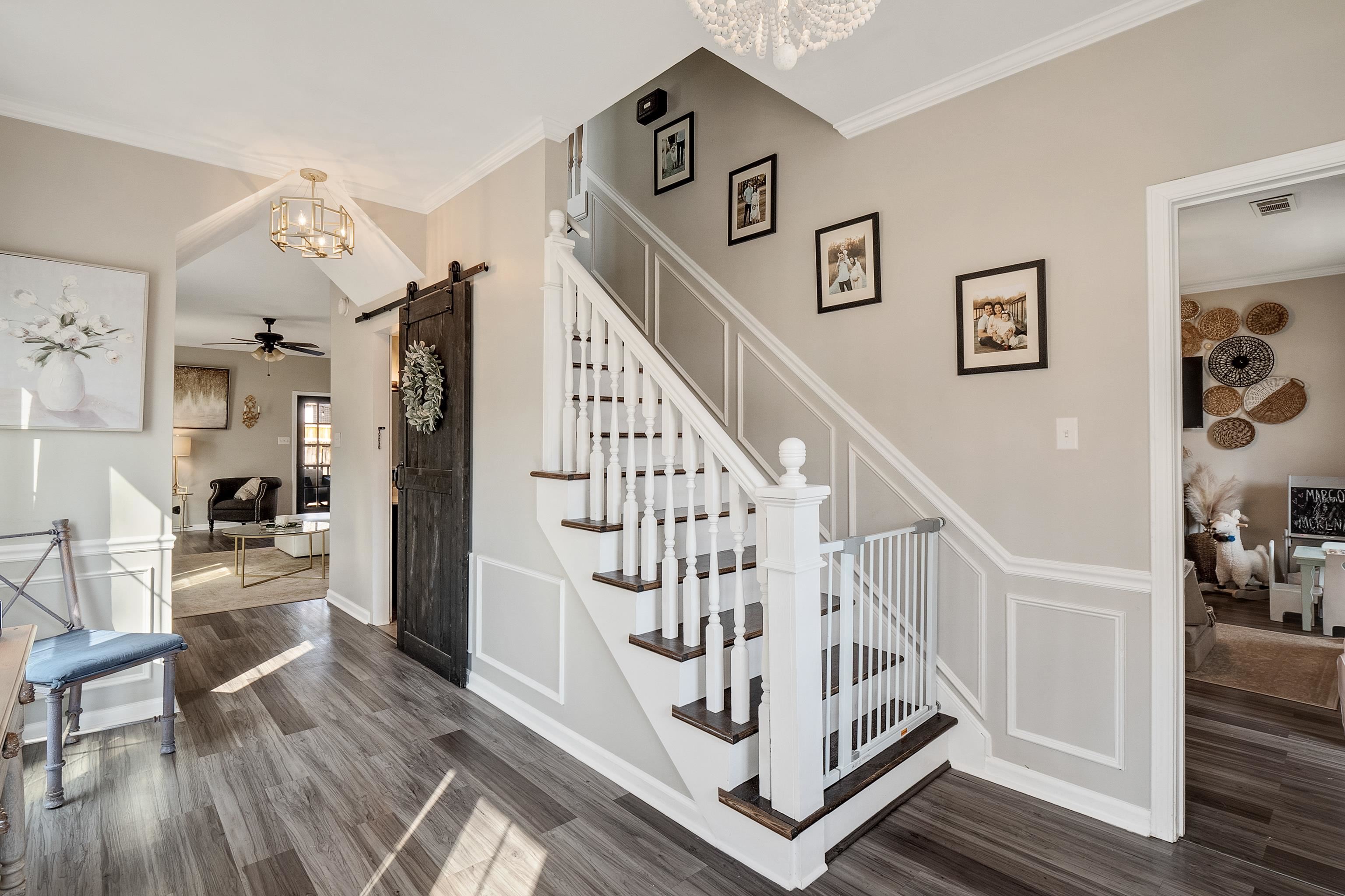 867 South Collierville Arlington Road Collierville, TN 38017 - Photo 10 of 35 Staircase with ornamental molding, hardwood / wood-style floors, ceiling fan with notable chandelier, and a barn door