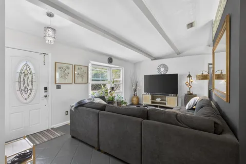 a living room with furniture and a chandelier