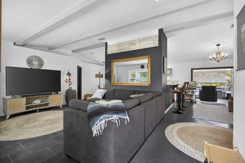 a living room with furniture a chandelier and a dining table