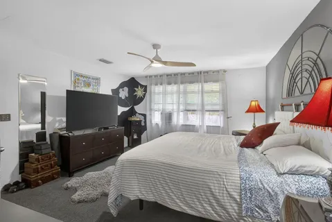 a bedroom with furniture and a flat screen tv