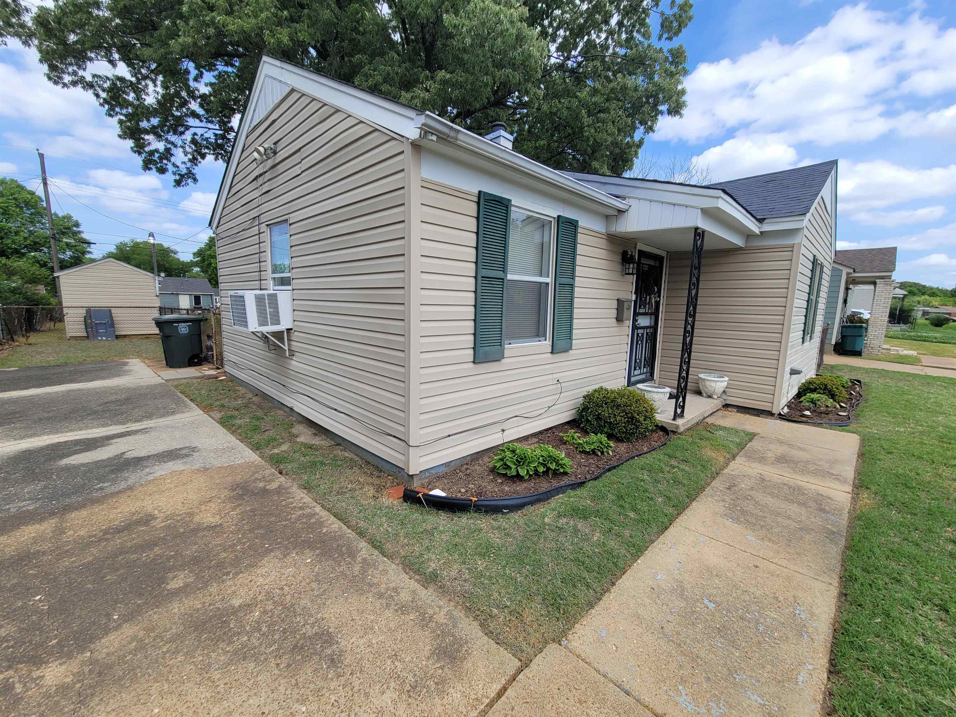 Bungalow-style home featuring a shingled roof, cooling unit, and a front yard