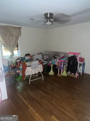 a playing room with furniture and a wooden floor