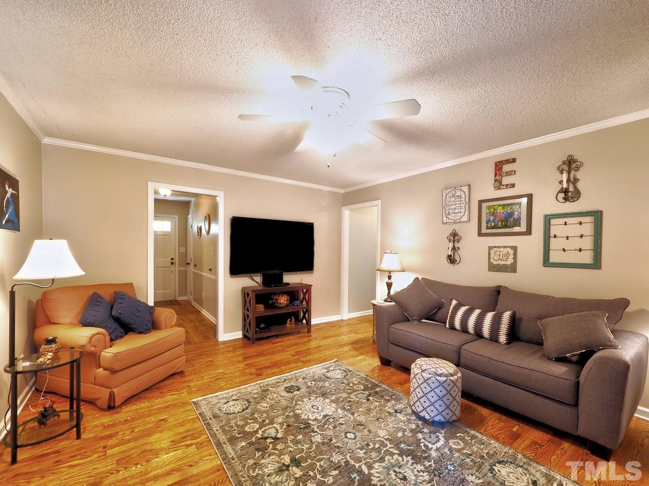 8329 Bells Lake Road Apex, NC 27539 - Photo 11 of 26 a living room with furniture and a flat screen tv