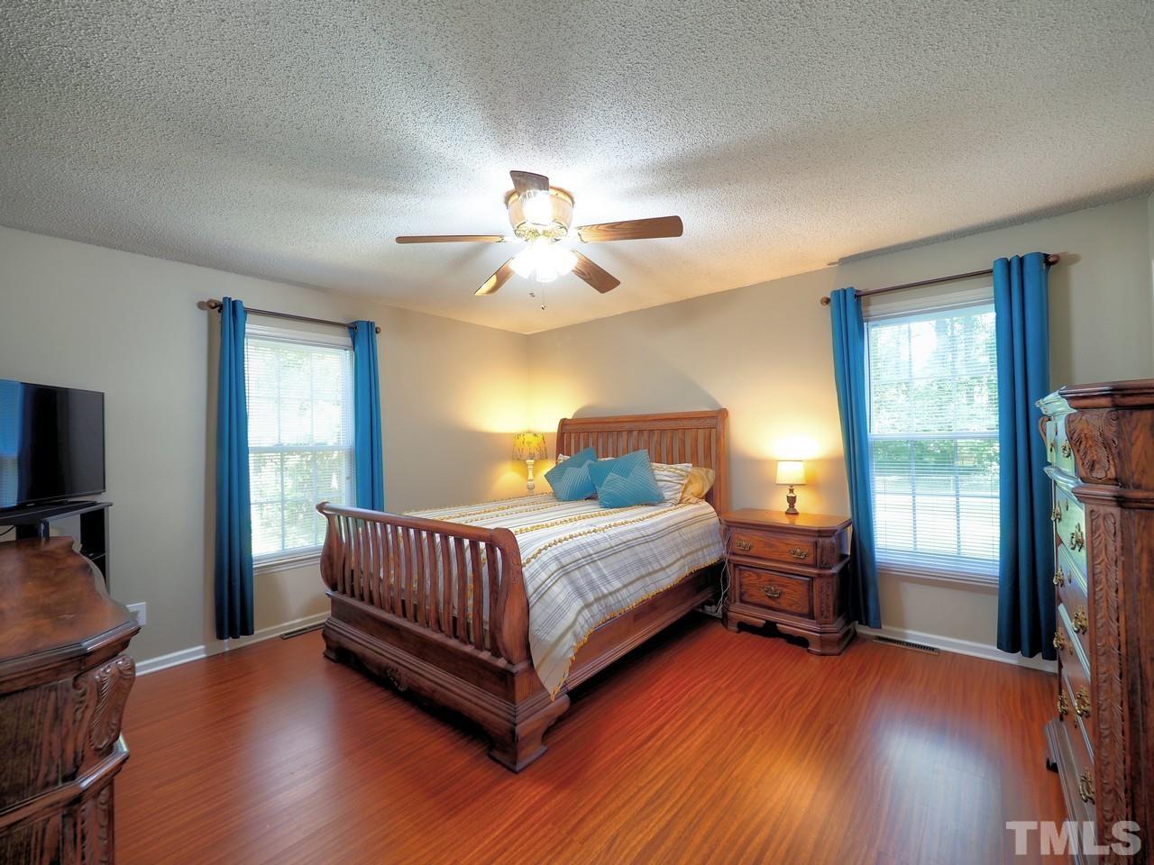 8329 Bells Lake Road Apex, NC 27539 - Photo 15 of 26 a bedroom with a bed and a chandelier