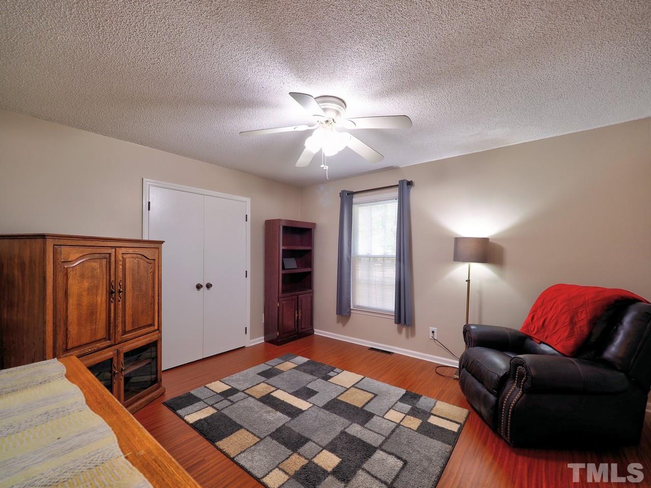 8329 Bells Lake Road Apex, NC 27539 - Photo 16 of 26 a bedroom with furniture and a rug
