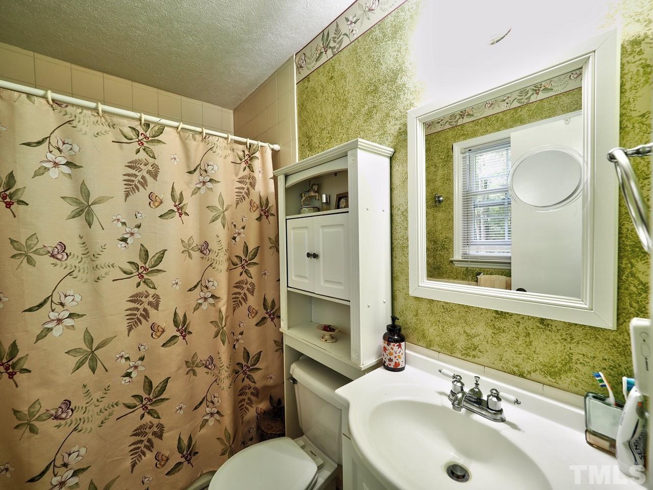 8329 Bells Lake Road Apex, NC 27539 - Photo 17 of 26 a bathroom with a sink and a mirror