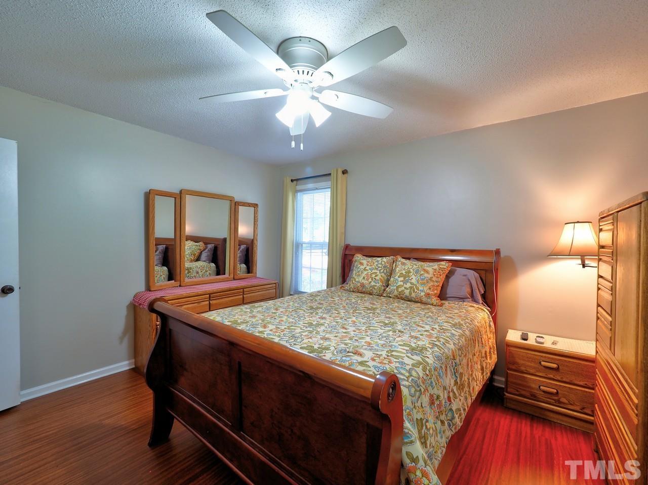 8329 Bells Lake Road Apex, NC 27539 - Photo 18 of 26 a bedroom with a bed and a dresser
