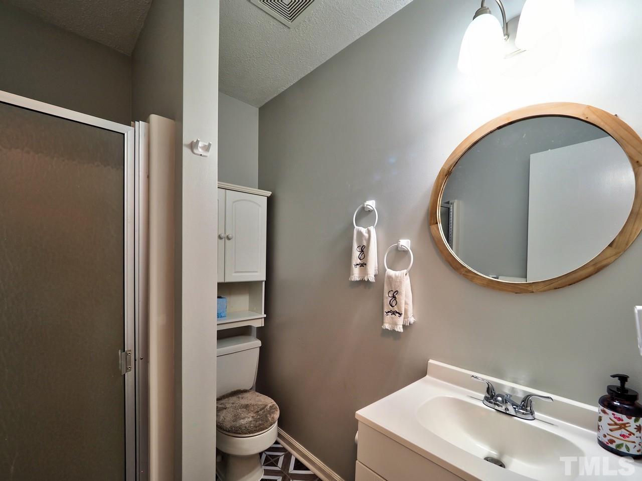 8329 Bells Lake Road Apex, NC 27539 - Photo 20 of 26 a bathroom with a sink and a mirror