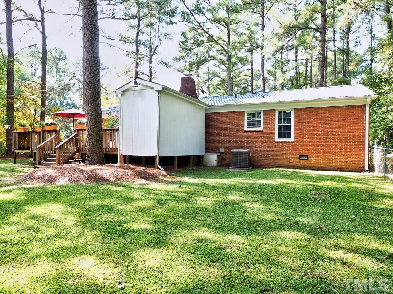 8329 Bells Lake Road Apex, NC 27539 - Photo 25 of 26 a backyard of a house with barbeque oven table and chairs