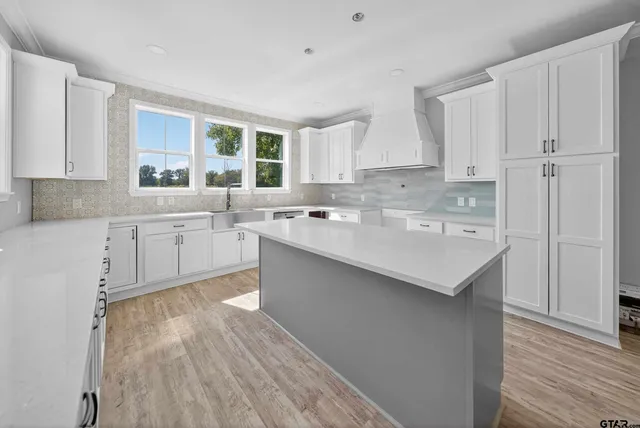 a kitchen with a sink white cabinets and white appliances