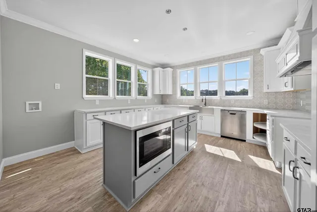 a kitchen with stainless steel appliances granite countertop a stove a sink and a microwave