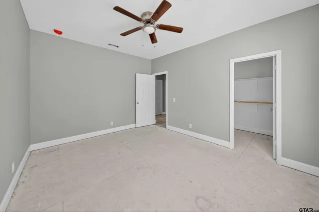 an empty room with closet and windows