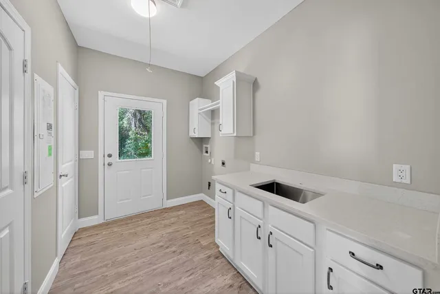 a kitchen with white cabinets and sink