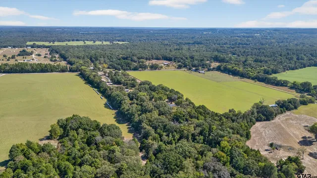 an aerial view of ocean and residential houses with outdoor space