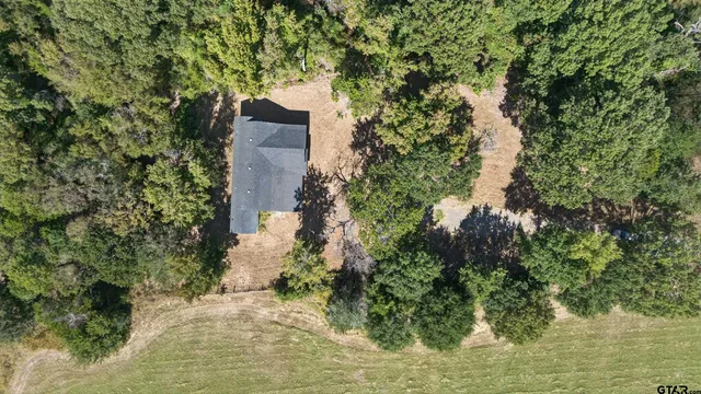 an aerial view of a house with a yard