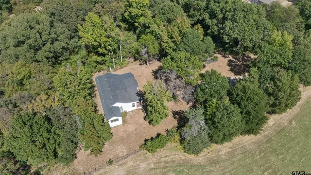 an aerial view of a house with a yard and a lake view