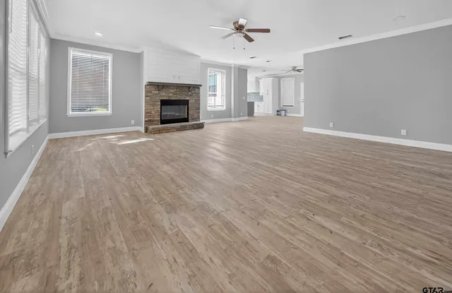 wooden floor fireplace and windows in an empty room