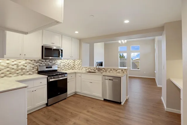 a kitchen with stainless steel appliances granite countertop a stove top oven a sink and a granite counter tops