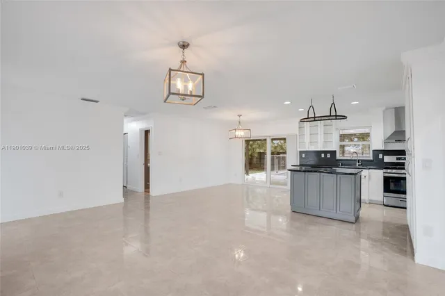 a view of kitchen with kitchen island stainless steel appliances refrigerator stove microwave and cabinets