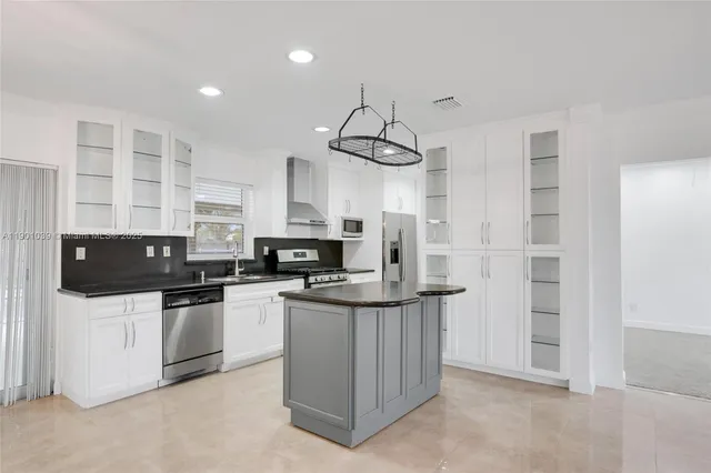 a kitchen with stainless steel appliances granite countertop a sink a stove and a refrigerator