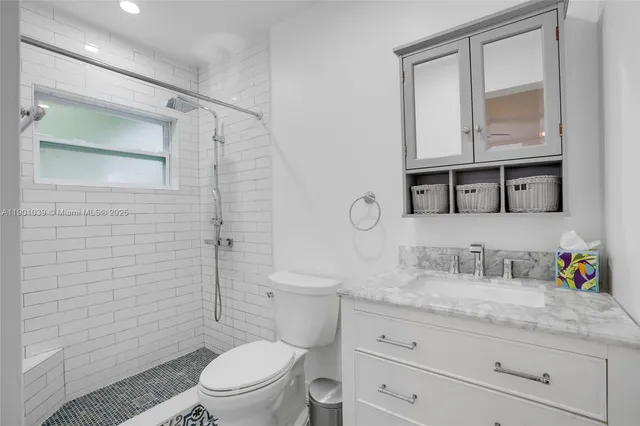a bathroom with a granite countertop sink a toilet and a mirror