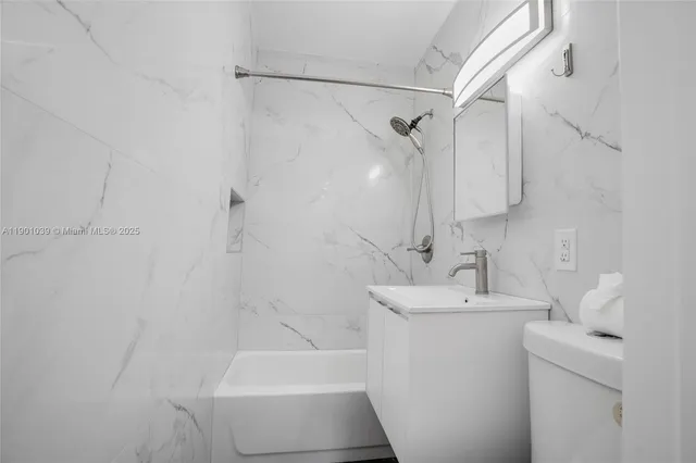 a white toilet sitting next to a bath tub