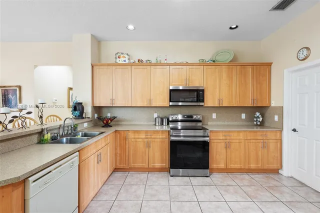 a kitchen with stainless steel appliances granite countertop a refrigerator and a stove top oven